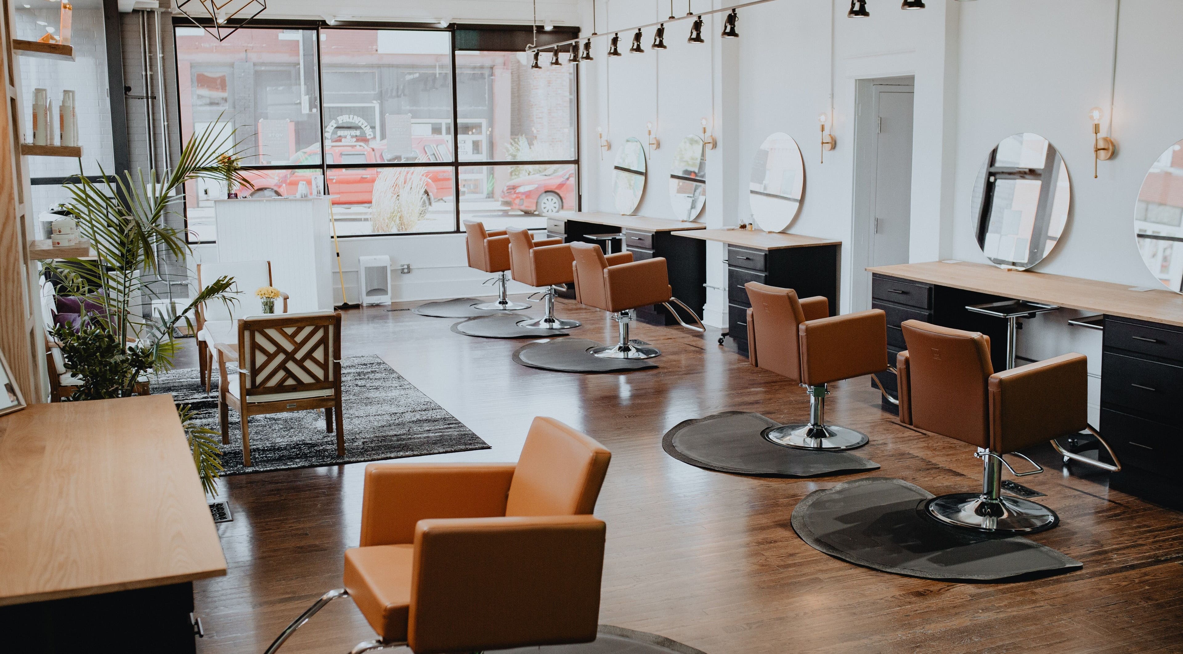 Modern salon interior of Vibe KC in Kansas City, Missouri, US with stylish chairs and mirrors.