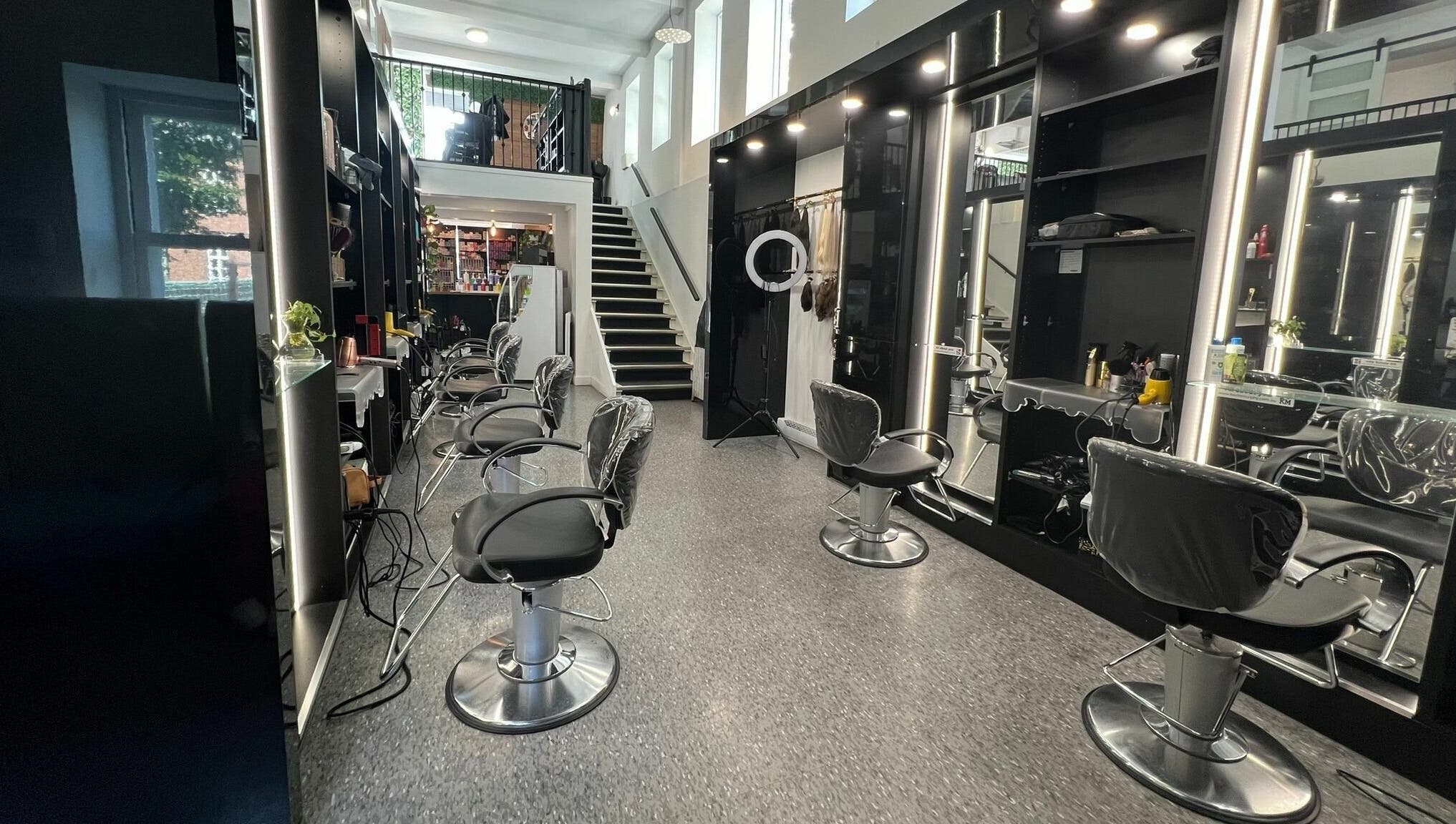 Intérieur élégant du salon Estilo Coiffure à Québec, Québec, CA, avec sièges modernes et escaliers.