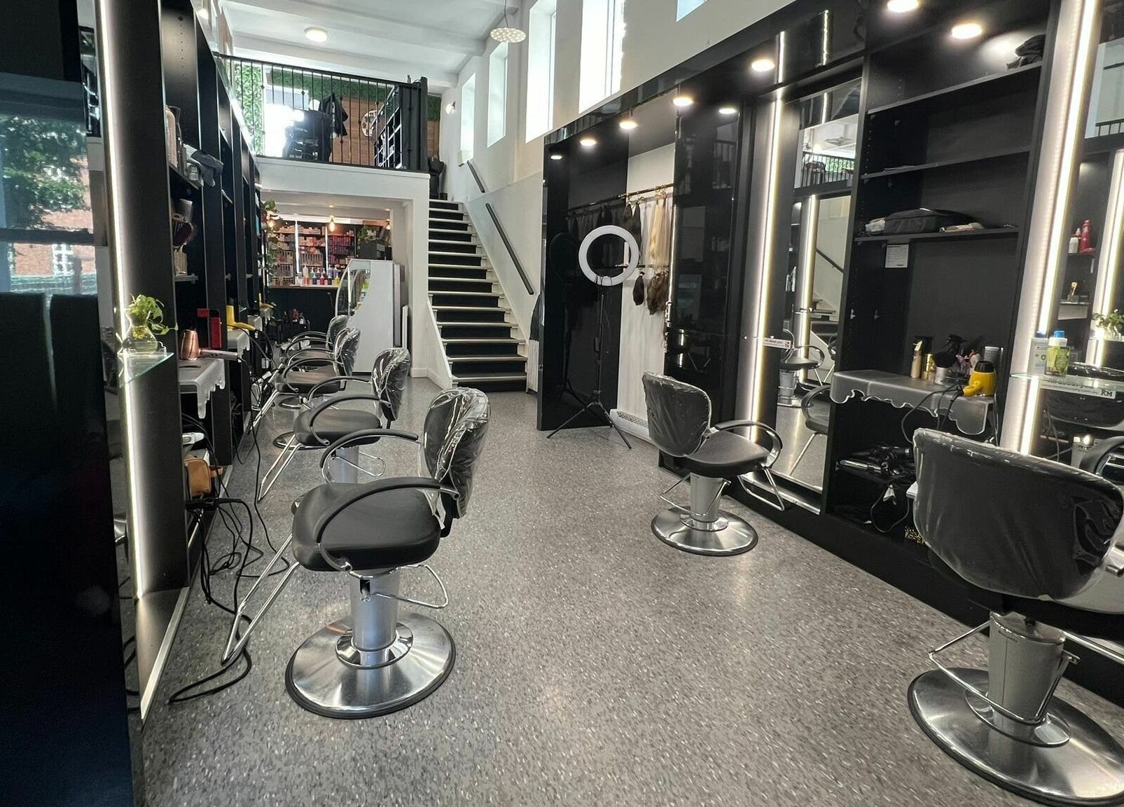 Intérieur élégant du salon Estilo Coiffure à Québec, Québec, CA, avec sièges modernes et escaliers.