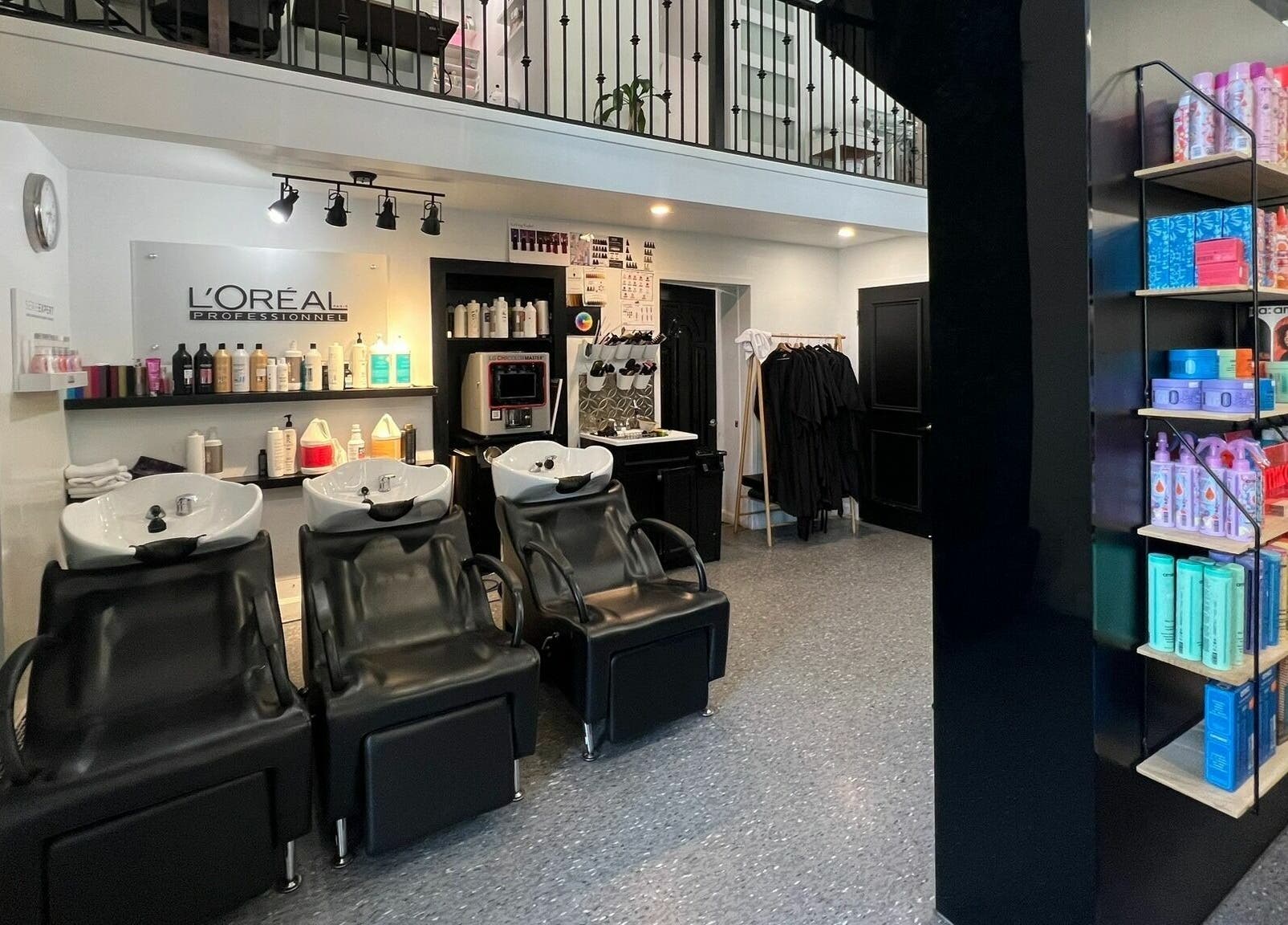 Intérieur moderne d'Estilo Coiffure à Québec, Québec, CA avec stations de lavage et produits capillaires.