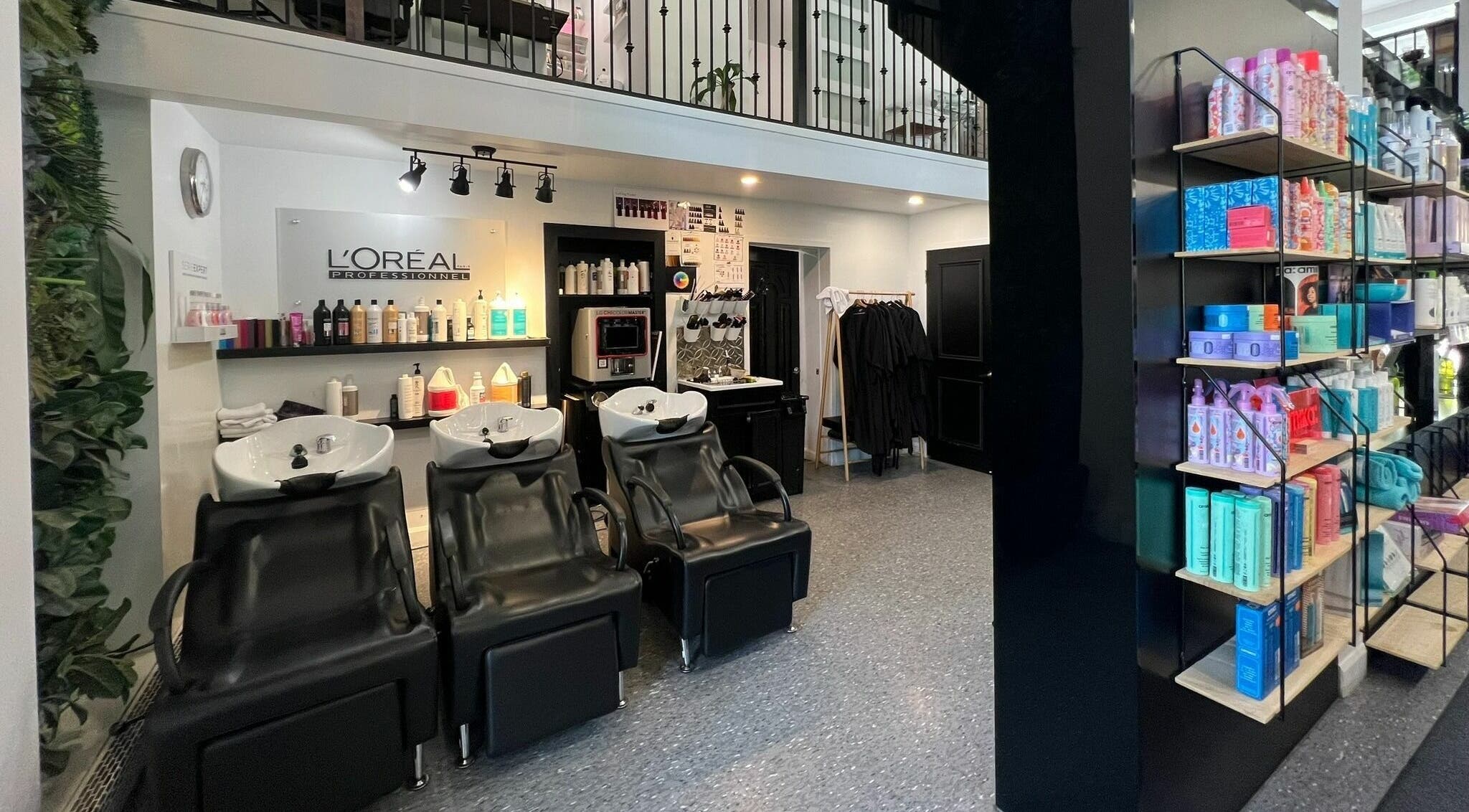 Intérieur moderne d'Estilo Coiffure à Québec, Québec, CA avec stations de lavage et produits capillaires.