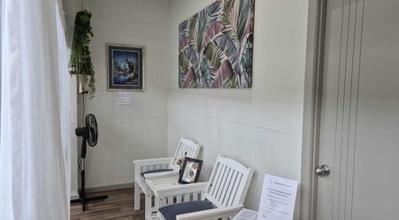 Relaxing reception area at Synergy Spinal Flow Studio, Mareeba, Queensland, AU with white chairs and vibrant art.