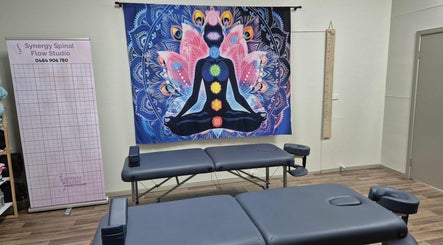 Therapy room at Synergy Spinal Flow Studio in Mareeba, Queensland, AU, showcasing chakra-themed decor and massage tables.