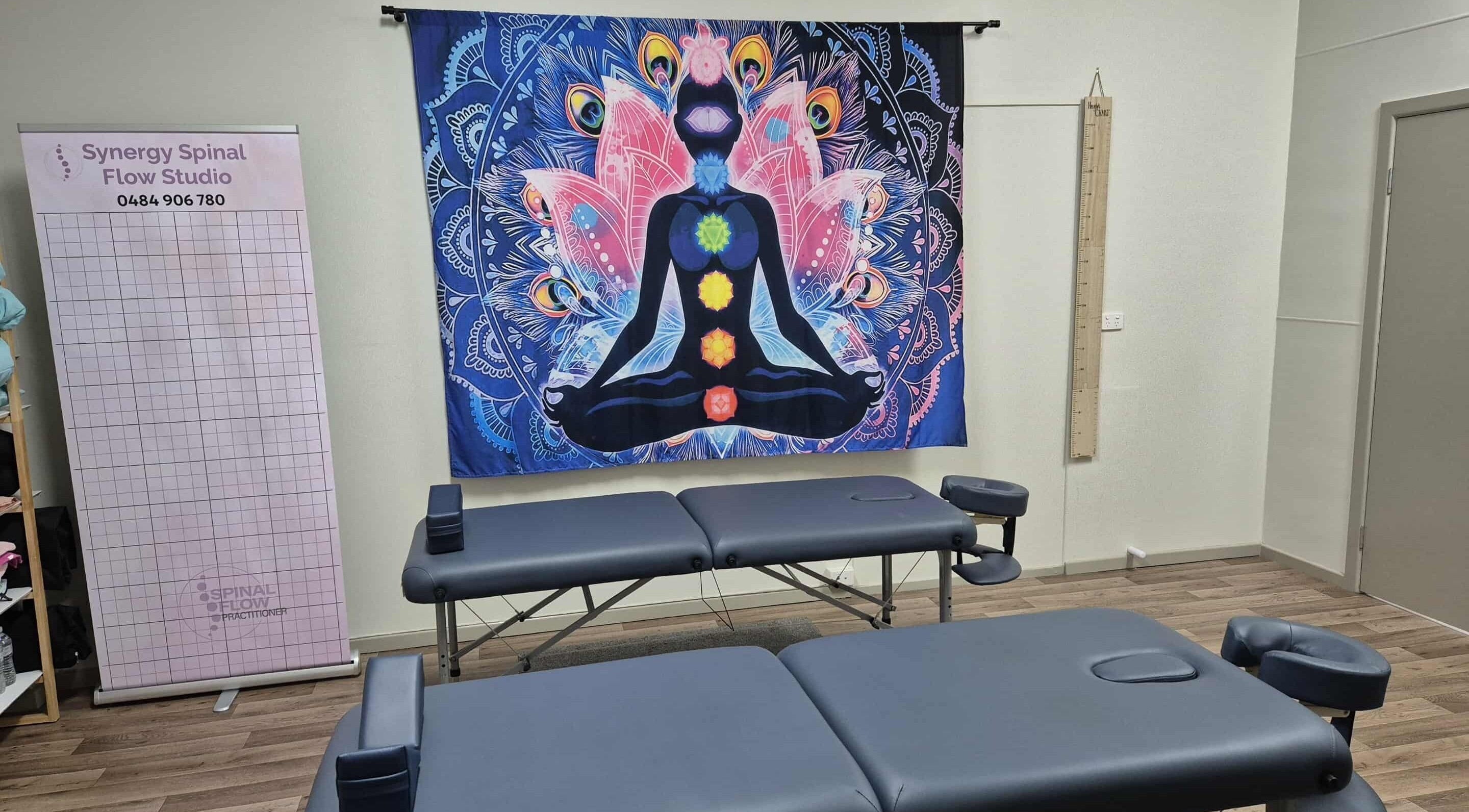 Synergy Spinal Flow Studio therapy room with chakra art in Mareeba, Queensland, AU.