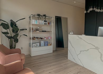 Réception élégante chez Addiction Santé Beauté, Blainville, Québec, CA, avec fauteuils et plantes.