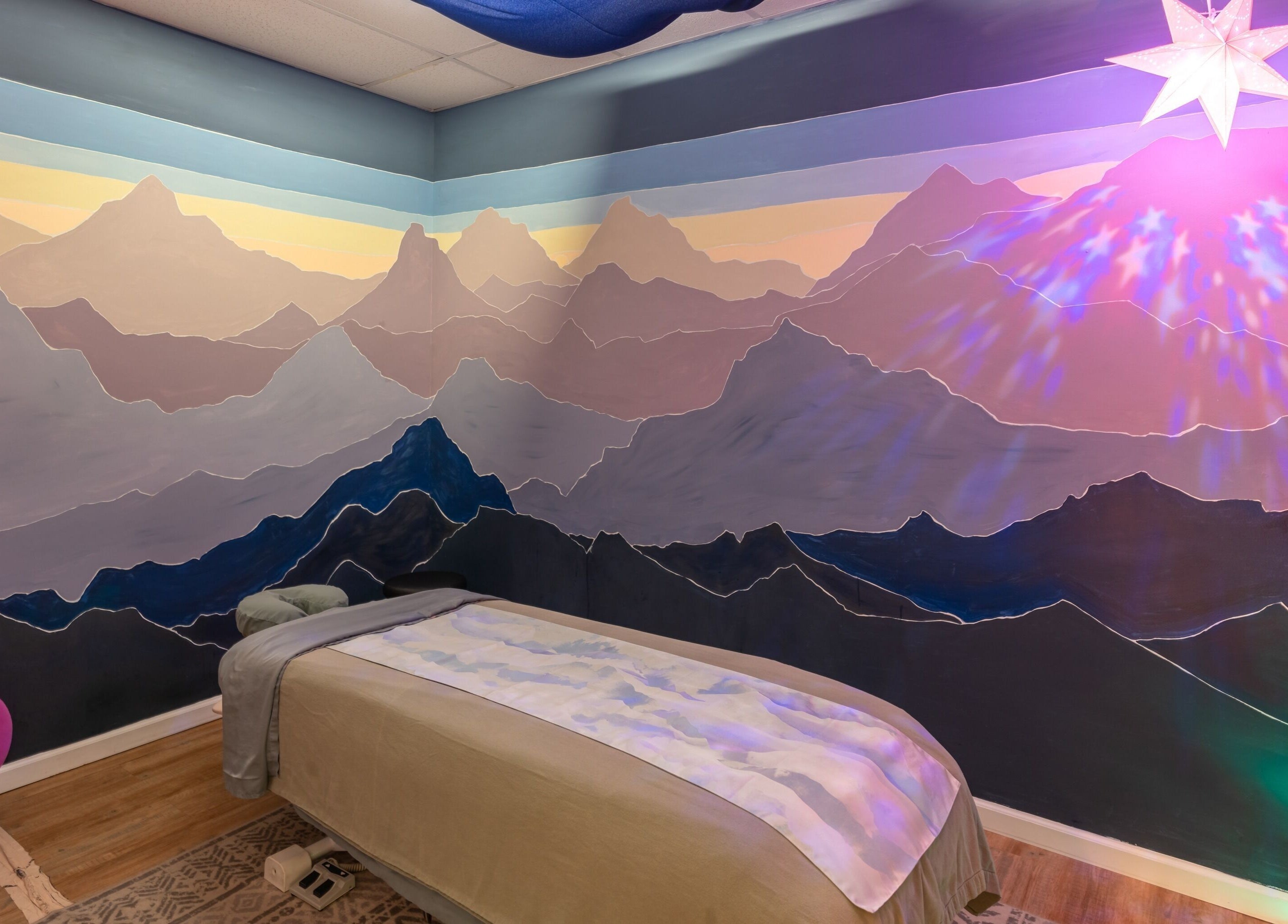 Tranquil massage room with a mountain mural at Healing Hippie, Hampstead, North Carolina, US.