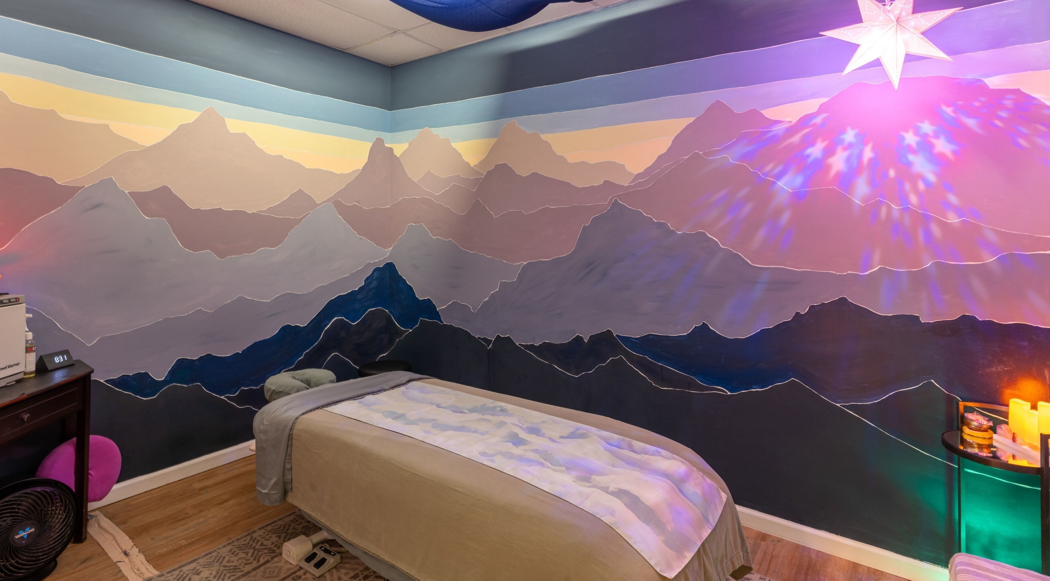Tranquil massage room with a mountain mural at Healing Hippie, Hampstead, North Carolina, US.