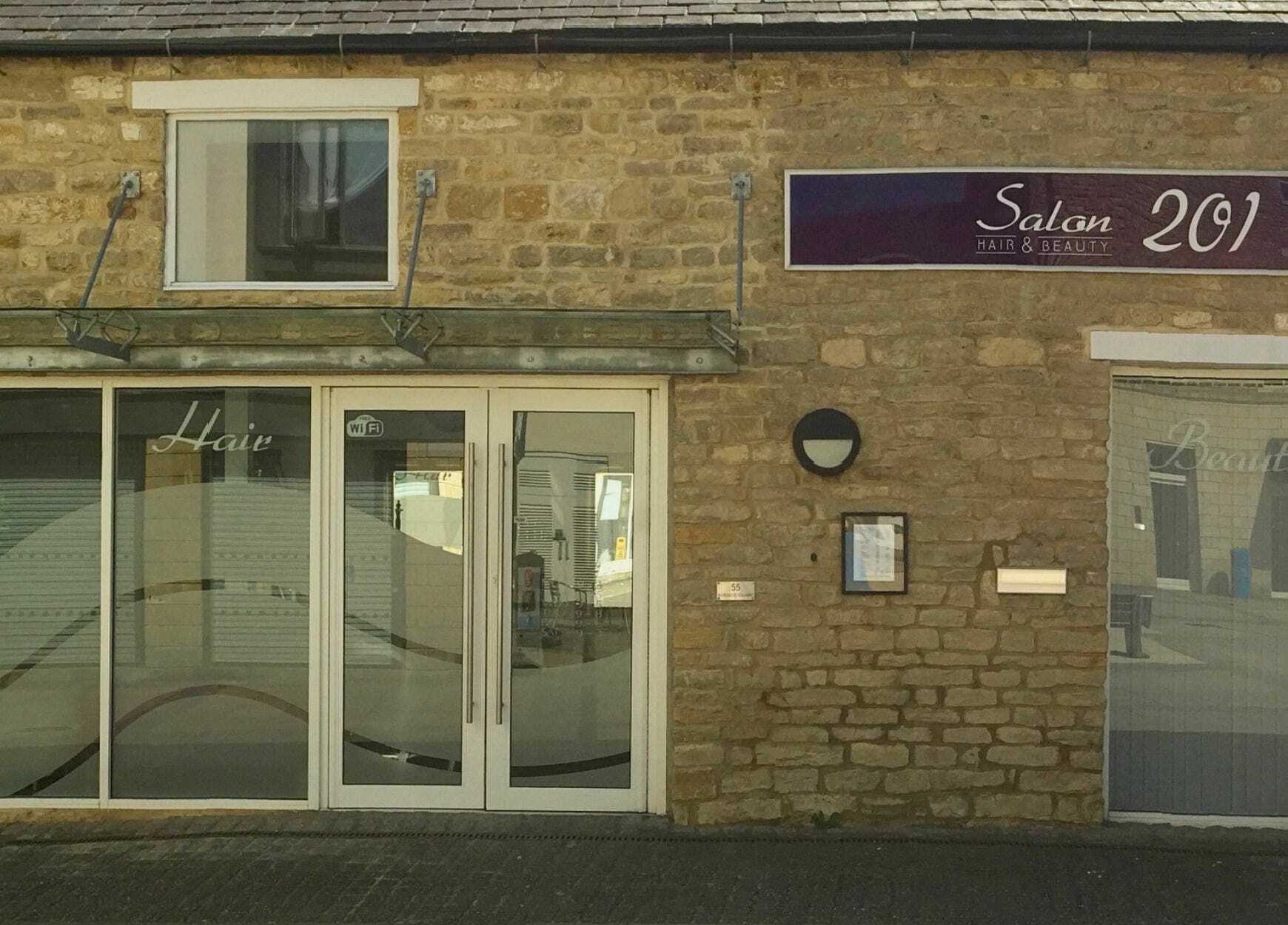 Front view of Hair salon in Brackley, England, GB, showcasing modern aesthetic and charming stone facade.