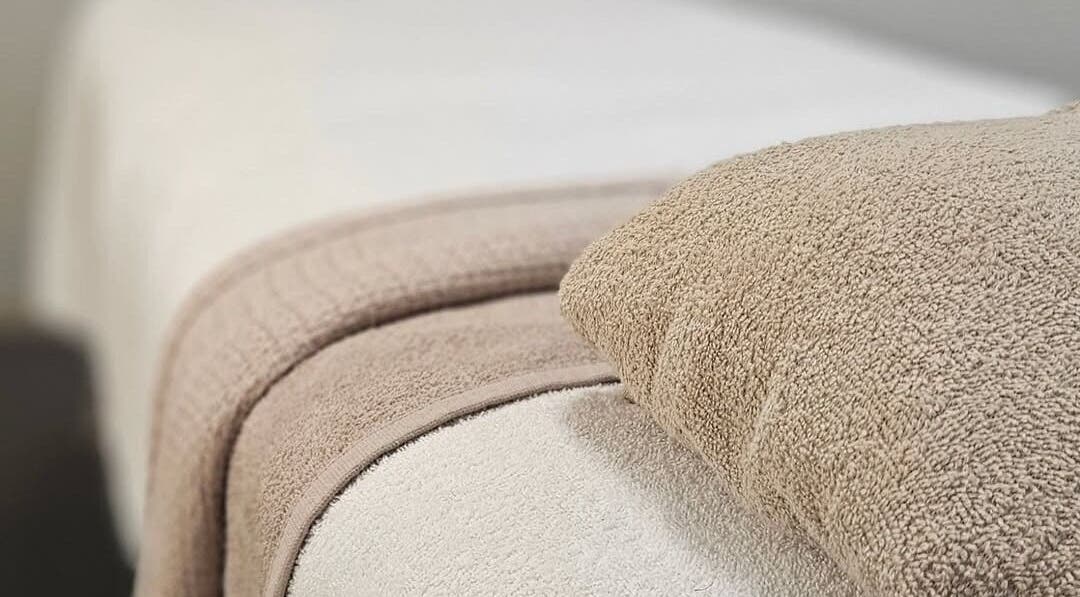 Soft beige towels at Beauty Habitz Salon in Parkwood, Queensland, AU, offering a tranquil spa experience.