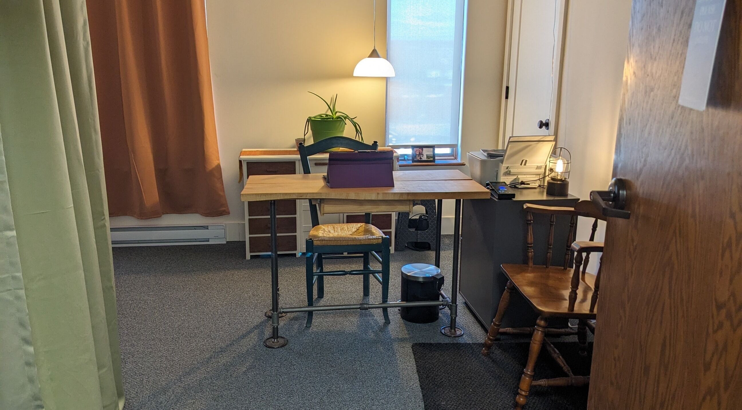 A cozy office space inside Leila M Percy Massage in Rockland, Maine, US with wooden chairs and a table.