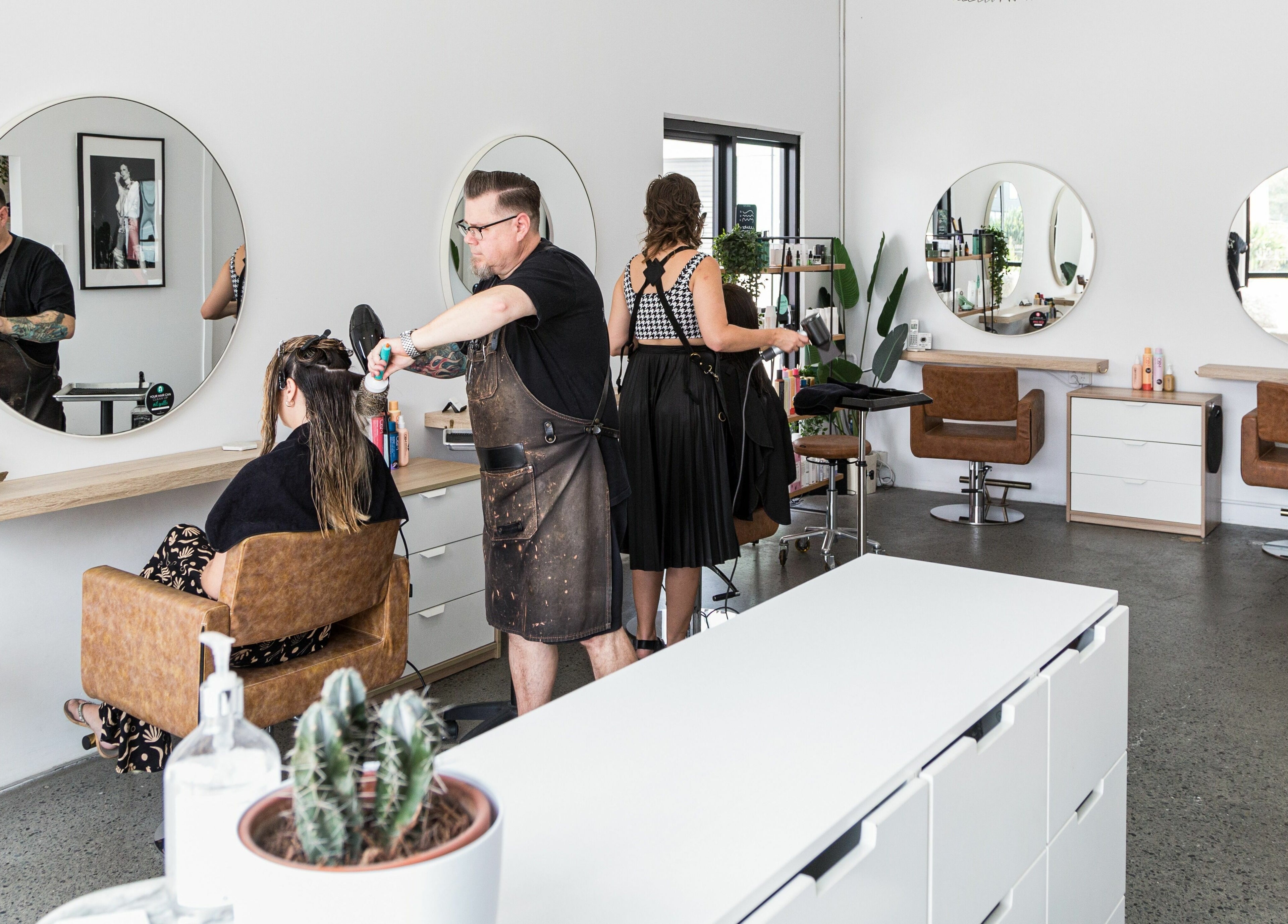 Stylists at Harris and Co. in Burleigh Heads, Queensland, AU, give hair treatments in a modern salon setting.