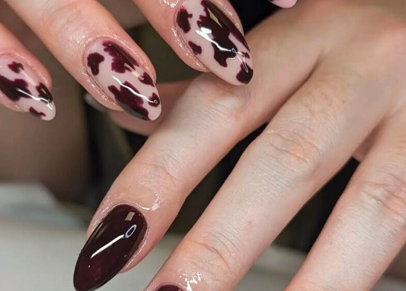 Bold burgundy nail art at Studio LAM, Peterborough, England, GB showcases intricate modern designs.