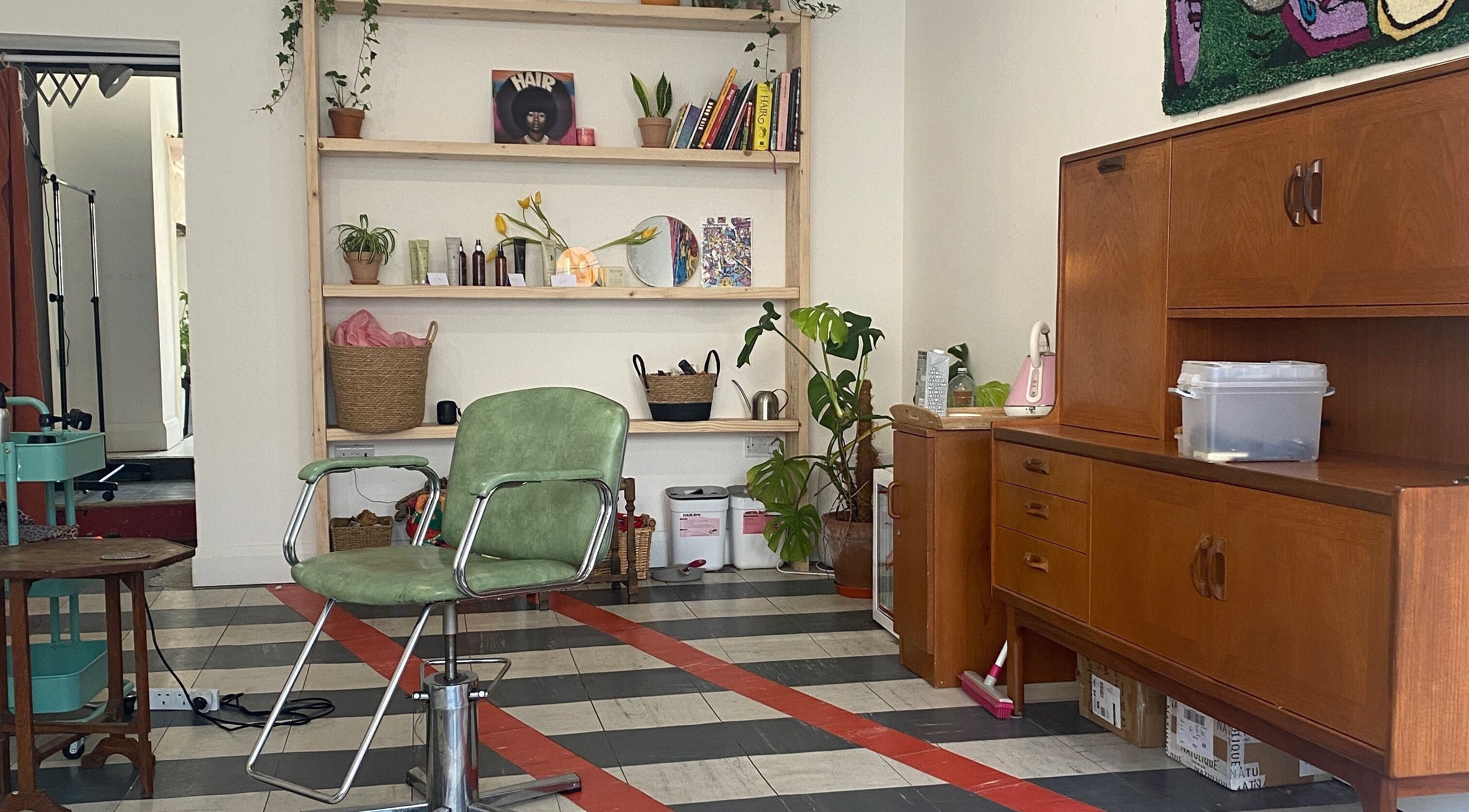 Cozy interior of Lily Beckett Hair in Todmorden, England, GB, featuring a vintage chair and stylish decor.