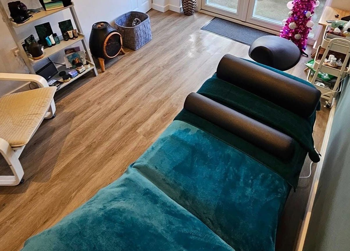Relaxing therapy room at The Reflex Clinic, Newton Aycliffe, England, GB, featuring cozy seating and treatment bed.