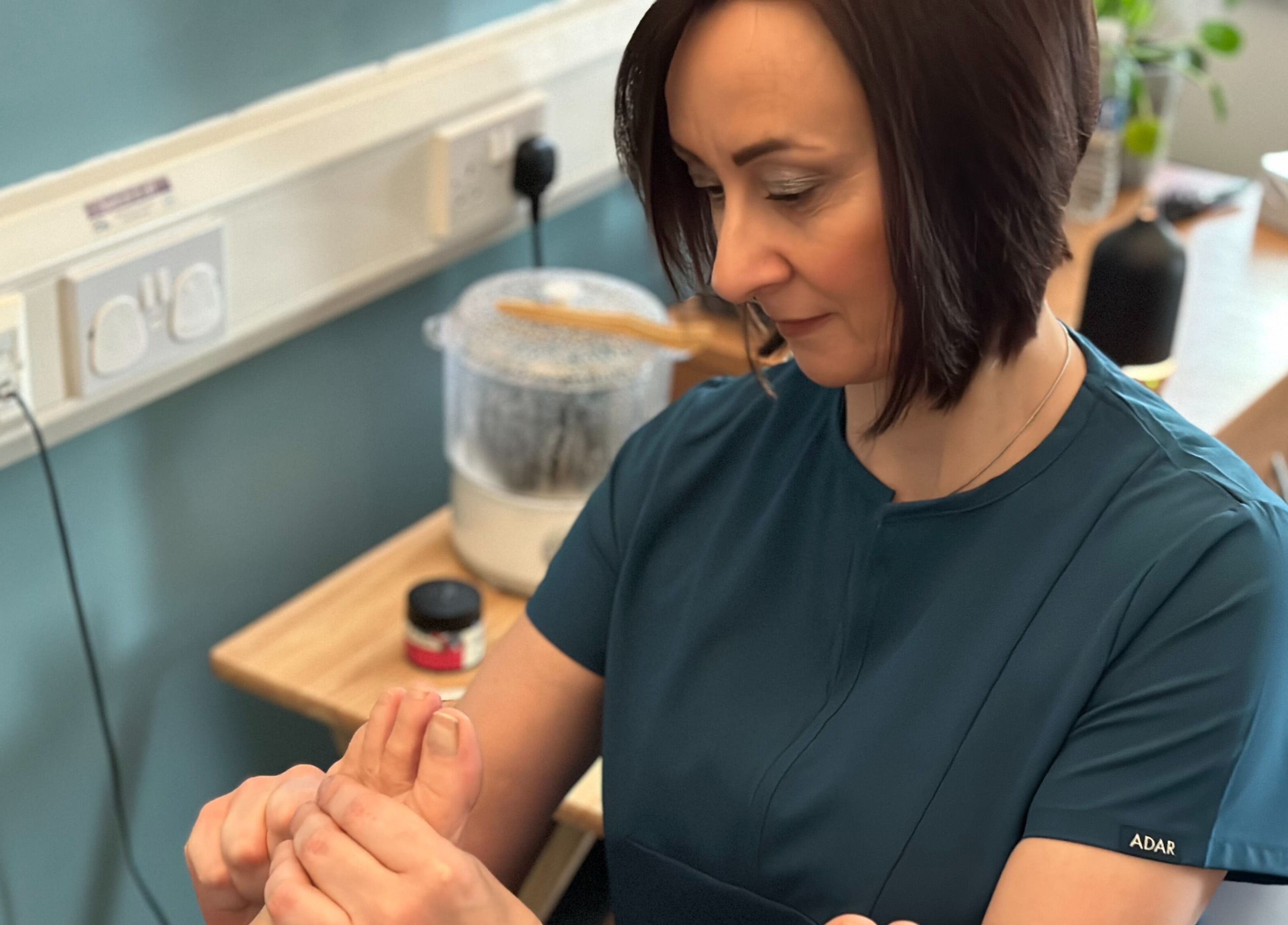 Therapist at The Reflex Clinic, Newton Aycliffe, England, performing a hand massage.