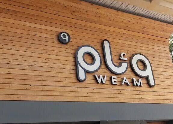 Exterior view of White Bamboo at Jeddah, Makkah Province, SA, showcasing a wooden facade with signage.