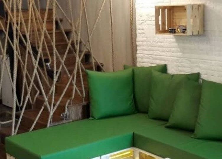 Cozy green lounge area at White Bamboo, Jeddah, Makkah Province, SA, featuring wooden decor and rope accents.