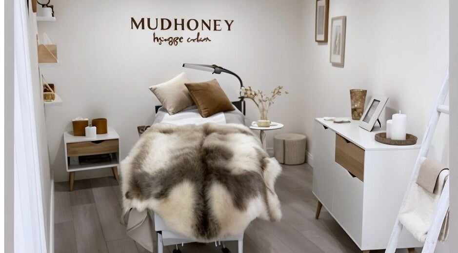 Luxurious treatment room at Mudhoney Beauty in Bainton, England, GB, showcasing warm decor and comfy linens.