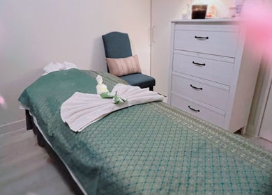 Tranquil massage room at Gussanova Thai Massage Therapy, London, England, GB, with a green bed and soothing decor.