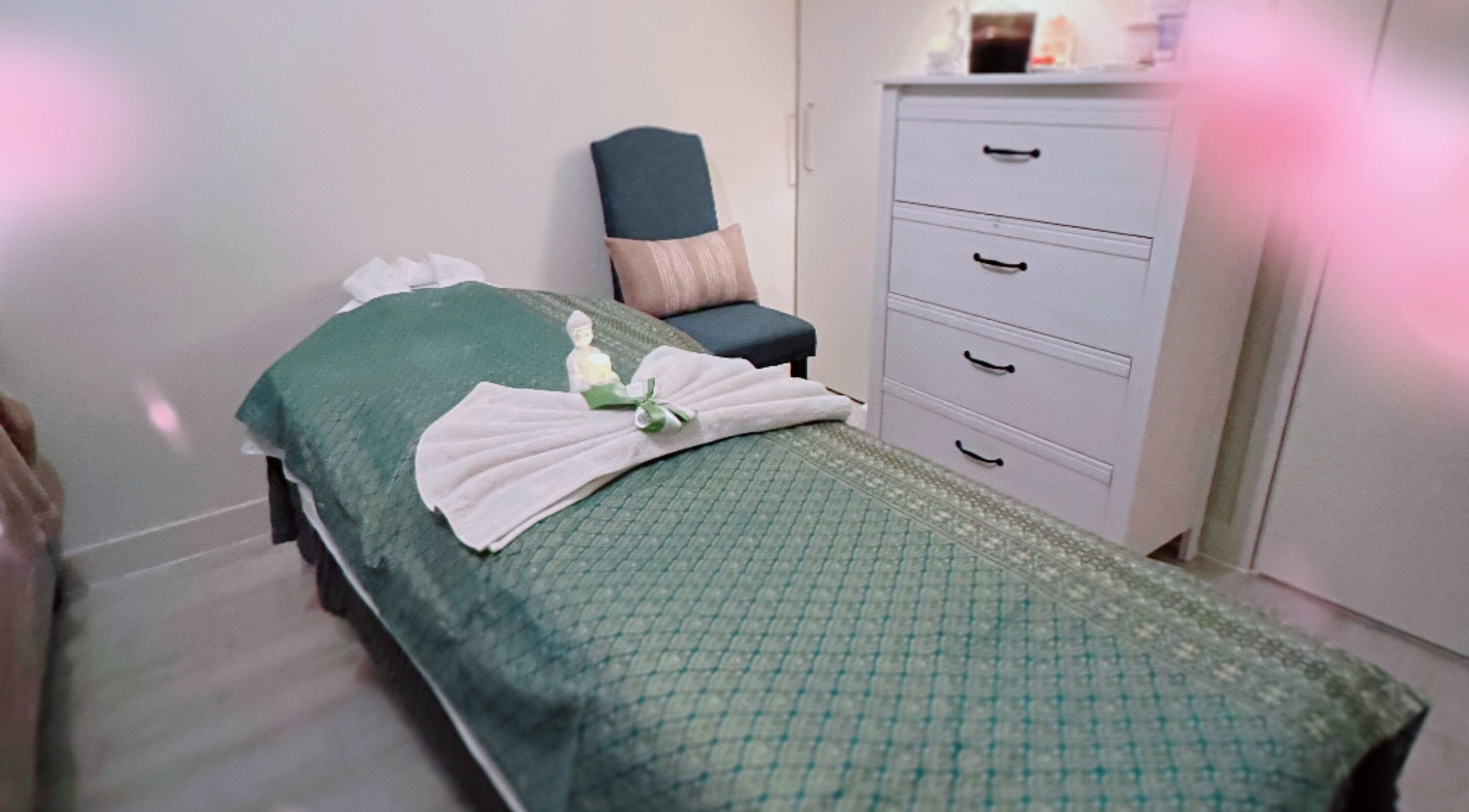 A tranquil massage room at Gussanova Thai Massage Therapy, London, England, GB, featuring a green bed cover.