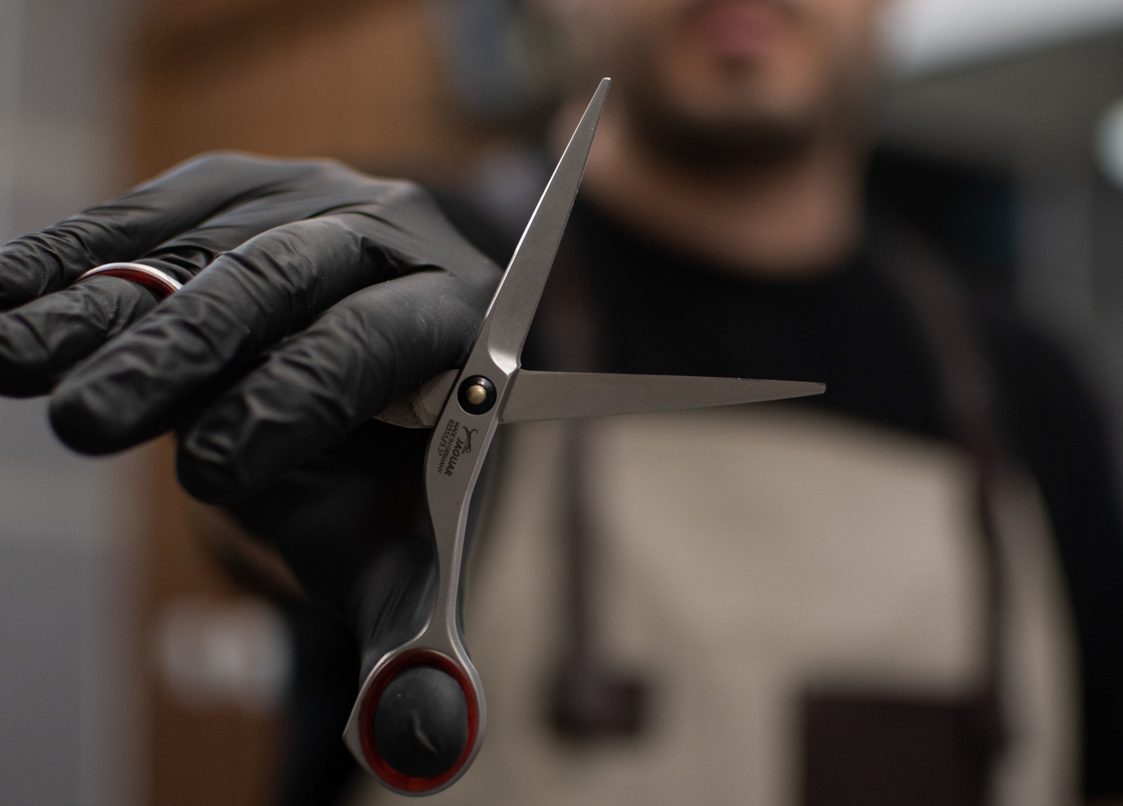 Бръснар държи професионални ножици в PRIVATE Barbershop, Варна, Варна, BG.