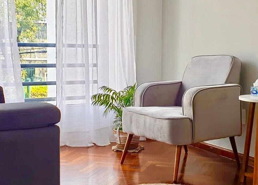 Acogedor rincón de salón en Samadhi, Montevideo, Departamento De Montevideo, UY, con silla y planta decorativa.