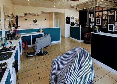 Modern interior of Head Honcho's Barbershop/Salon in Newton Abbot, England, GB, showcasing styling stations and decor.