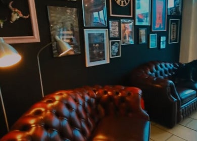 Chic lounge area with leather sofas at Head Honcho's Barbershop/Salon in Newton Abbot, England, GB.