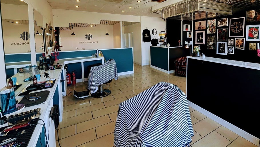 Modern interior of Head Honcho's Barbershop/Salon in Newton Abbot, England, GB with stylish decor and barber chairs.