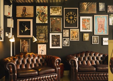Chic lounge with leather sofas and art at Head Honcho's Barbershop/Salon, Newton Abbot, England, GB.