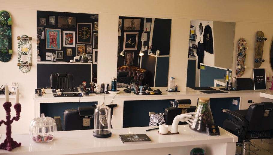 Modern interior of Head Honcho's Barbershop/Salon in Newton Abbot, England, GB with chic decor and skateboards on walls.