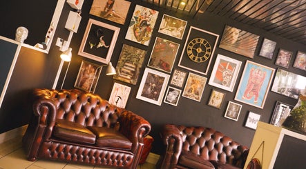 Stylish seating area at Head Honcho's Barbershop/Salon in Newton Abbot, England, GB, featuring unique wall art.