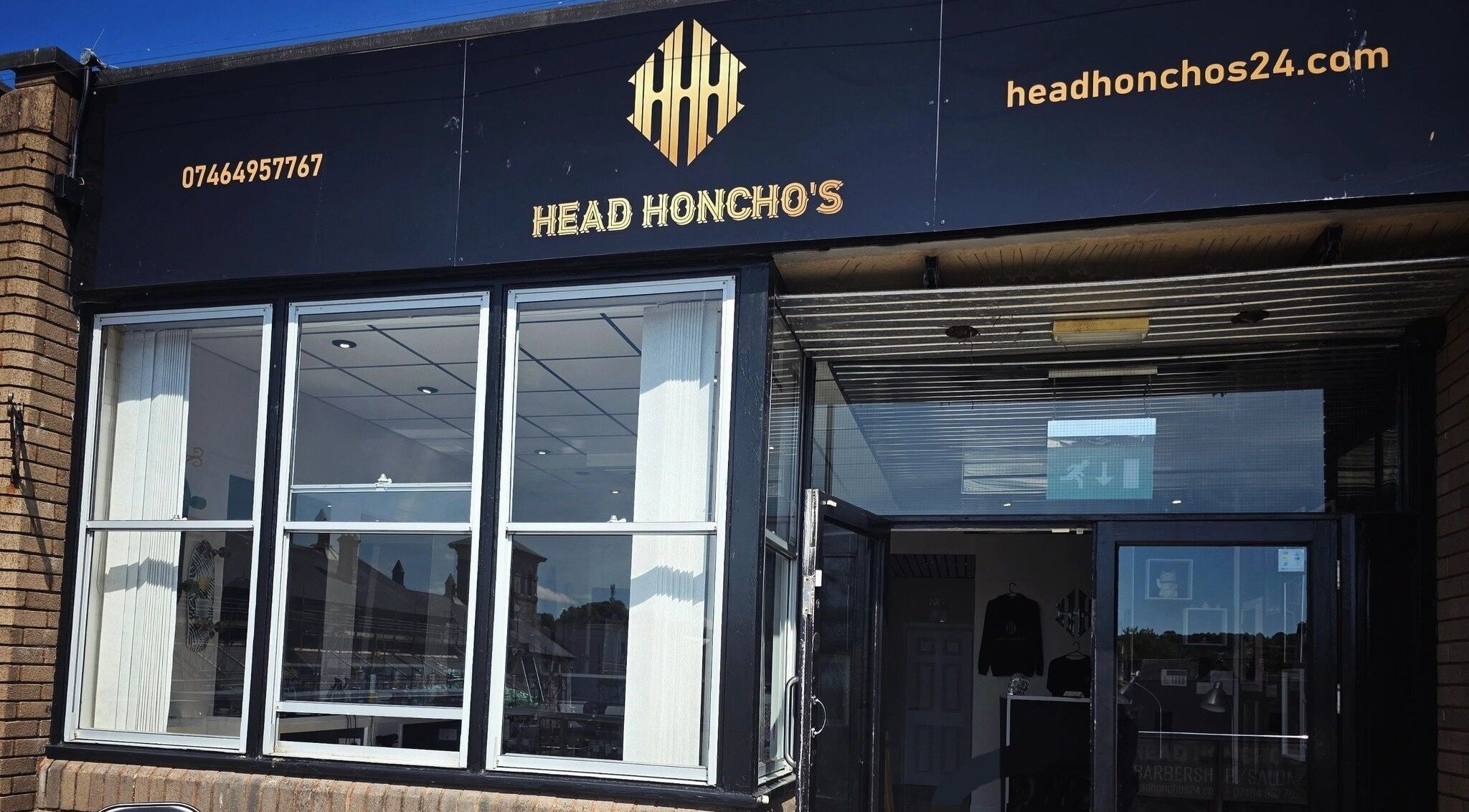 Front view of Head Honcho's Barbershop/Salon, Newton Abbot, England, showcasing modern exterior design.