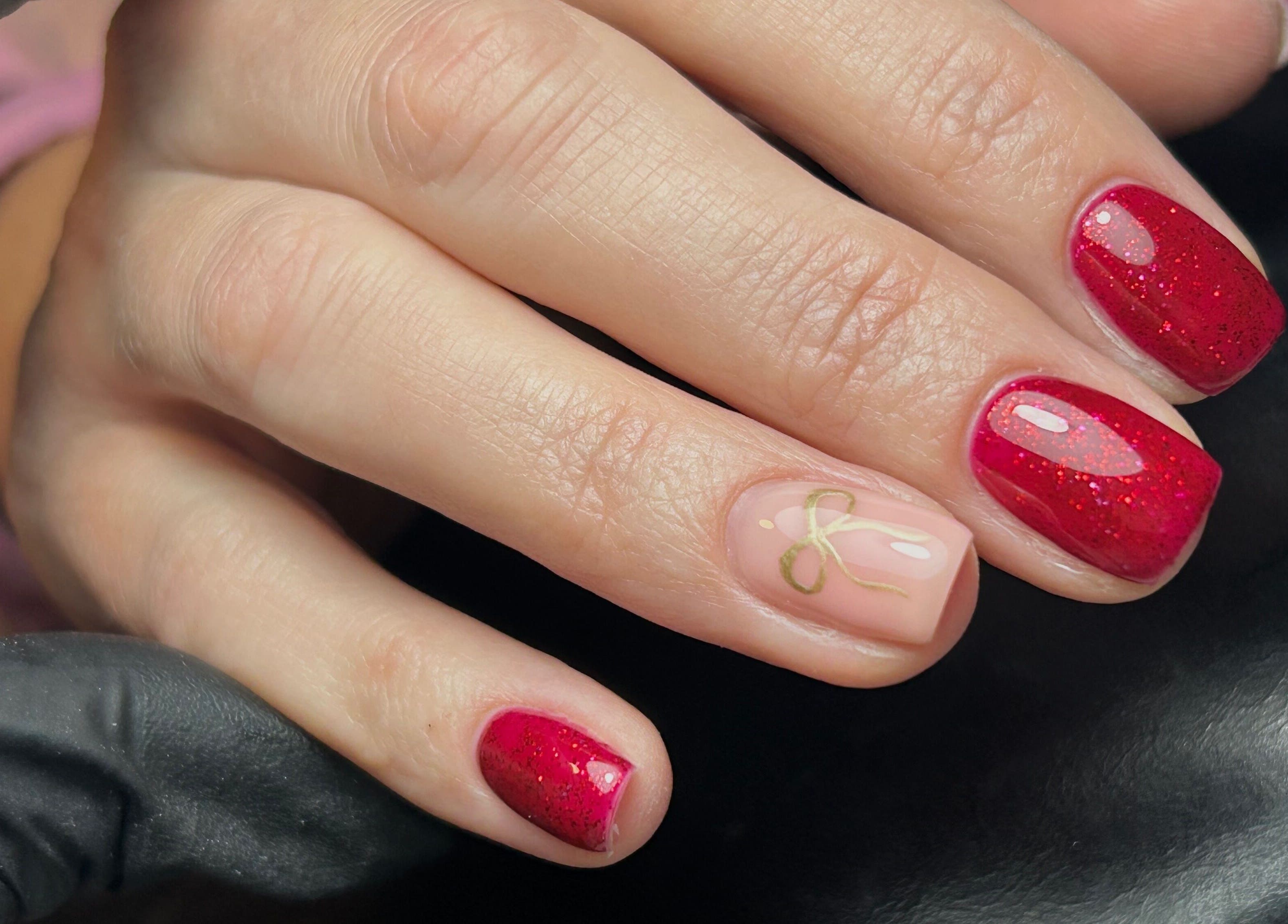 Red glitter nails with delicate art at TW Beauty and Nails, Milford Haven, Wales, GB.