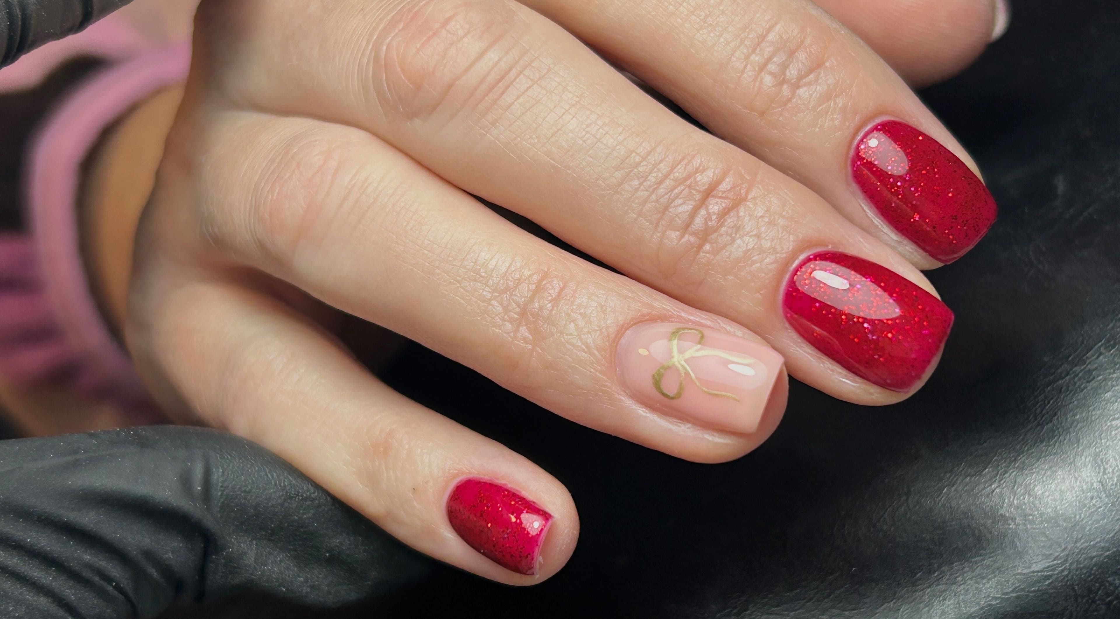 Red glitter nails with delicate art at TW Beauty and Nails, Milford Haven, Wales, GB.