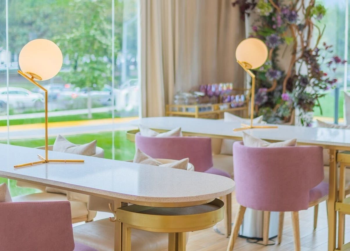 Interior moderno de Lilabelle en San Pedro Garza García, Nuevo León, MX, con elegantes mesas y sillas rosas.