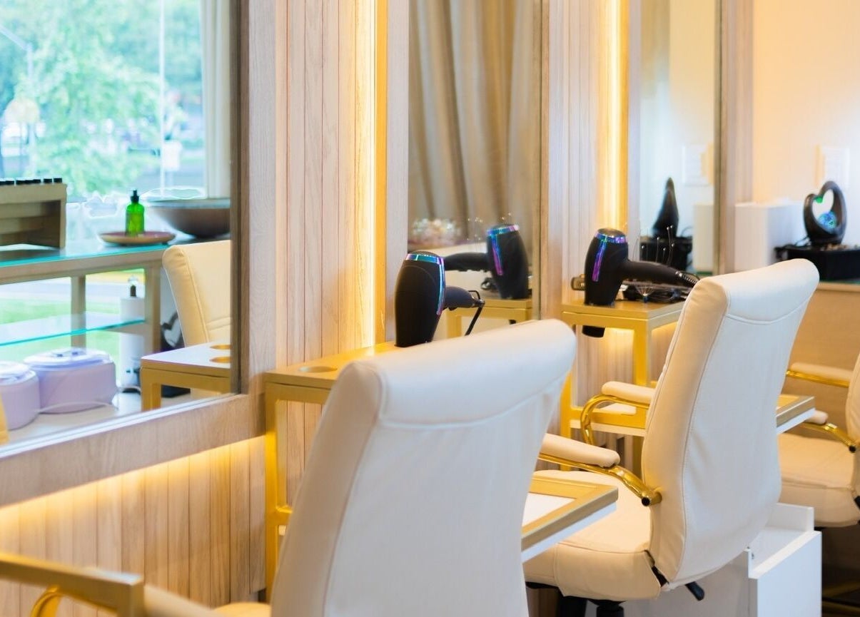 Acogedor espacio de belleza en Lilabelle, San Pedro Garza García, Nuevo León, MX con sillas y espejos iluminados.