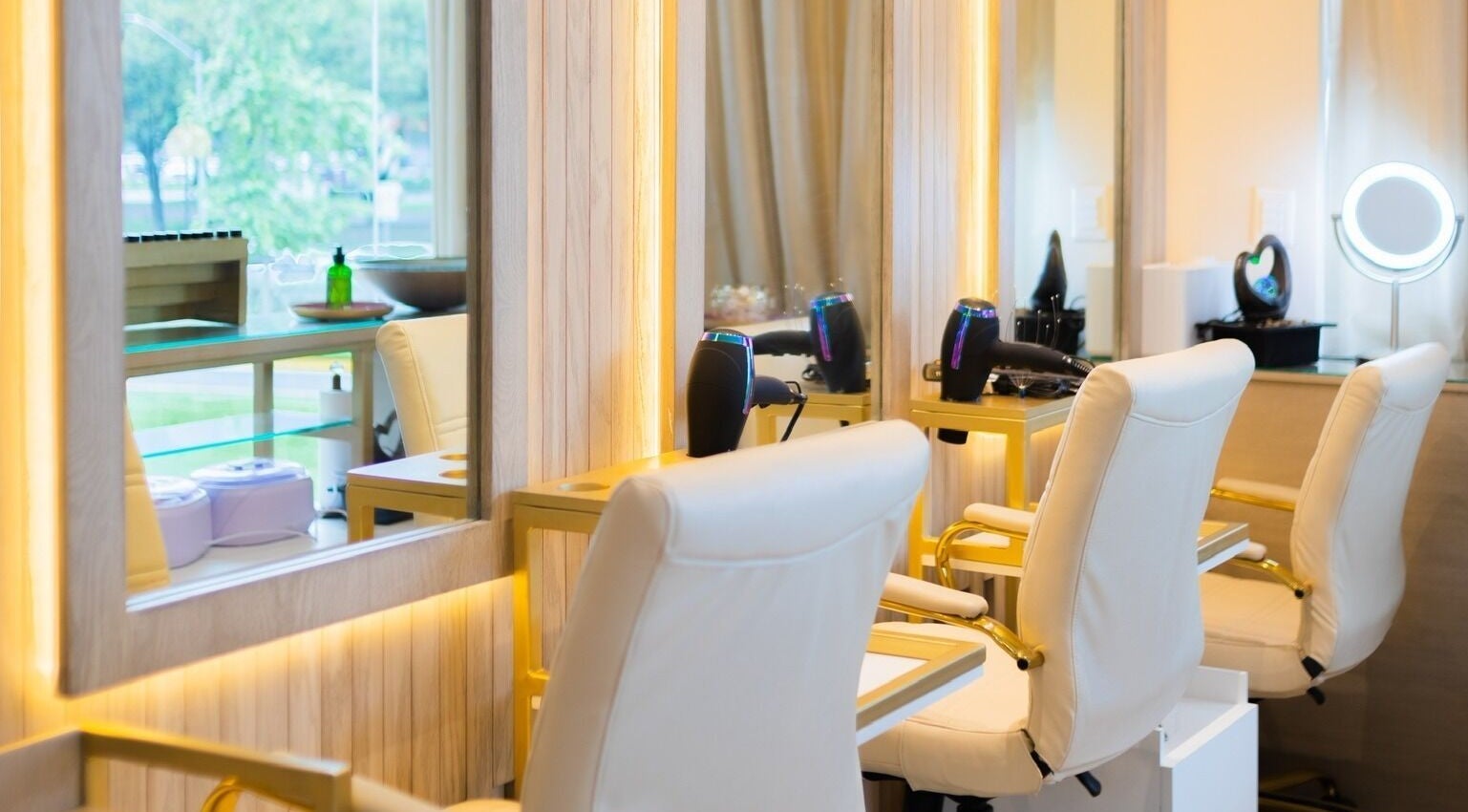 Acogedor espacio de belleza en Lilabelle, San Pedro Garza García, Nuevo León, MX con sillas y espejos iluminados.