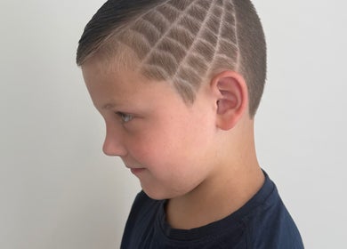 Side view of a boy with a stylish patterned haircut at Anarchy Barber Shop, Logan Reserve, Queensland, AU.