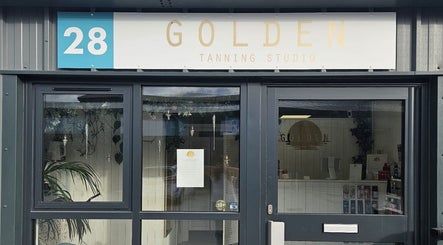 Entrance of Golden Tanning Studio, Wadebridge, England, GB with clear signage above the door.