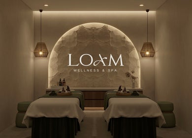Relaxing spa room at LOAM Wellness & Spa in Las Vegas, Nevada, US, featuring massage tables and ambient lighting.