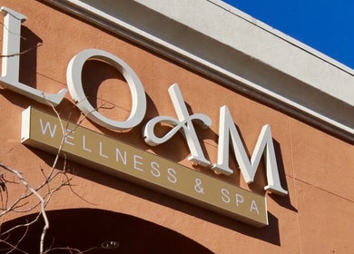 Entrance sign of LOAM Wellness & Spa in Las Vegas, Nevada, US against a clear blue sky.