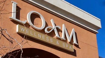 Entrance sign of LOAM Wellness & Spa in Las Vegas, Nevada, US against a clear blue sky.