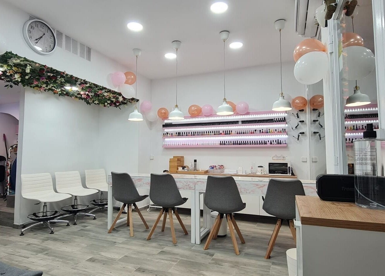 Interior elegante de Passion Nails & Lashes en Barcelona, Catalunya, ES, con sillas modernas y decoración floral.