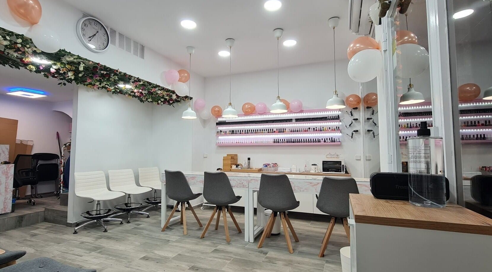 Interior elegante de Passion Nails & Lashes en Barcelona, Catalunya, ES, con sillas modernas y decoración floral.