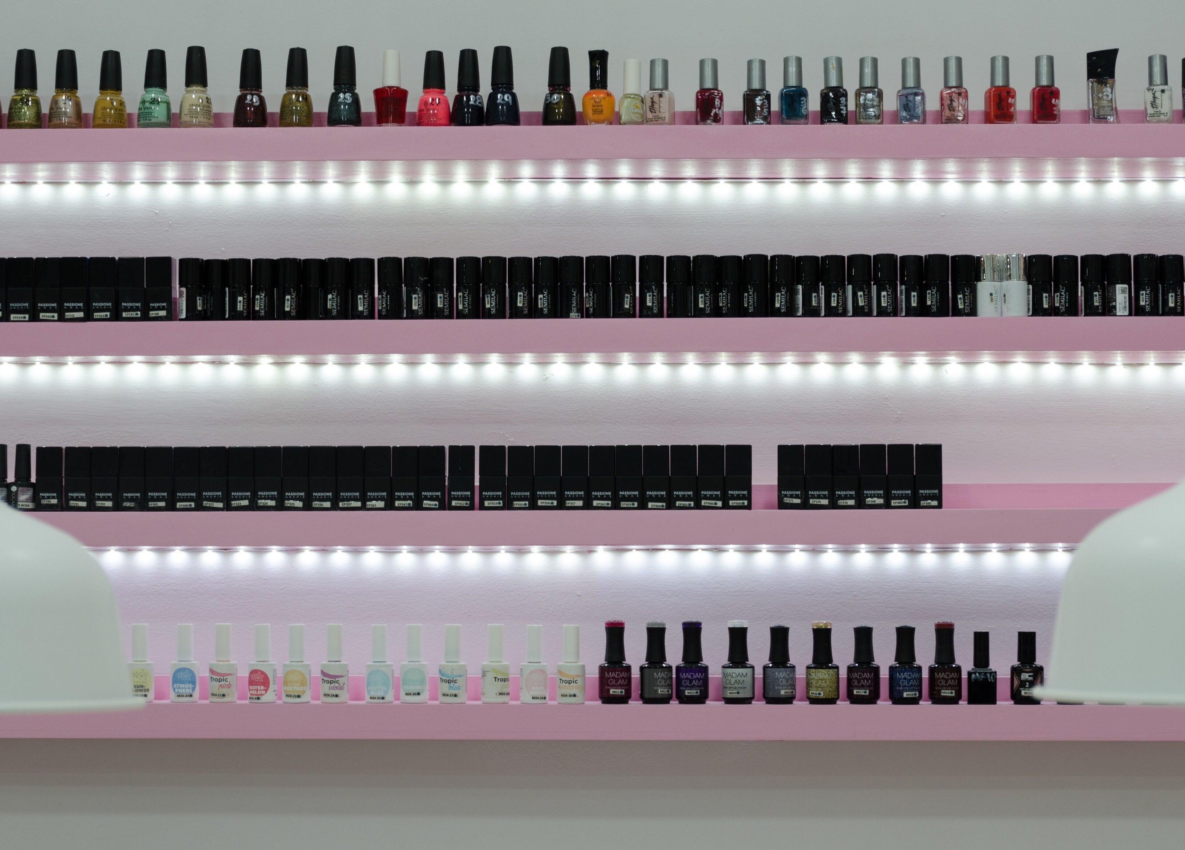 Estantes de esmaltes iluminados en Passion Nails & Lashes, Barcelona, Catalunya, ES.