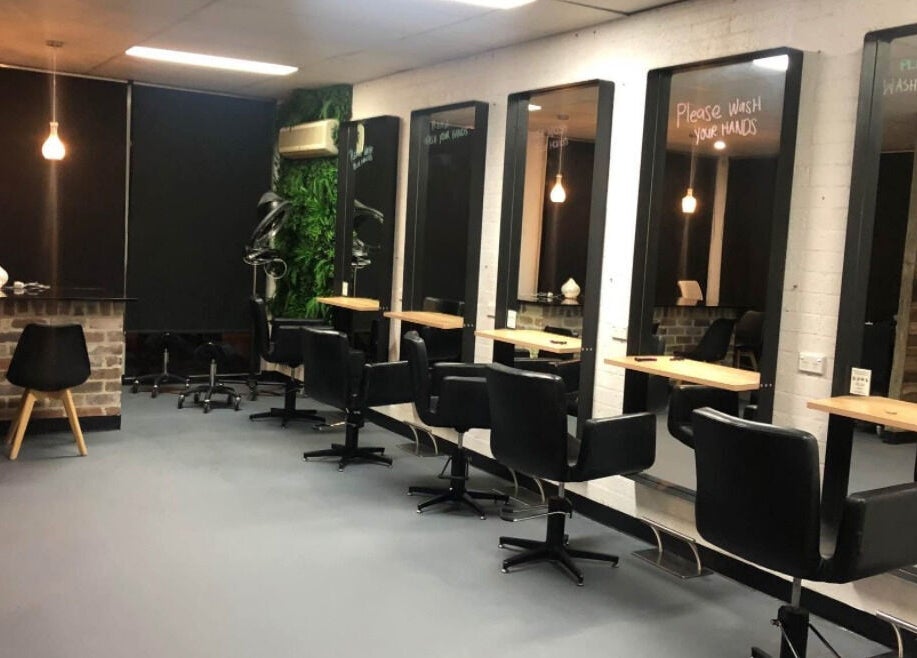 Modern interior of Blondes & Blowouts Tuggerah, featuring stylish black chairs and large mirrors in Tuggerah, New South Wales, AU.