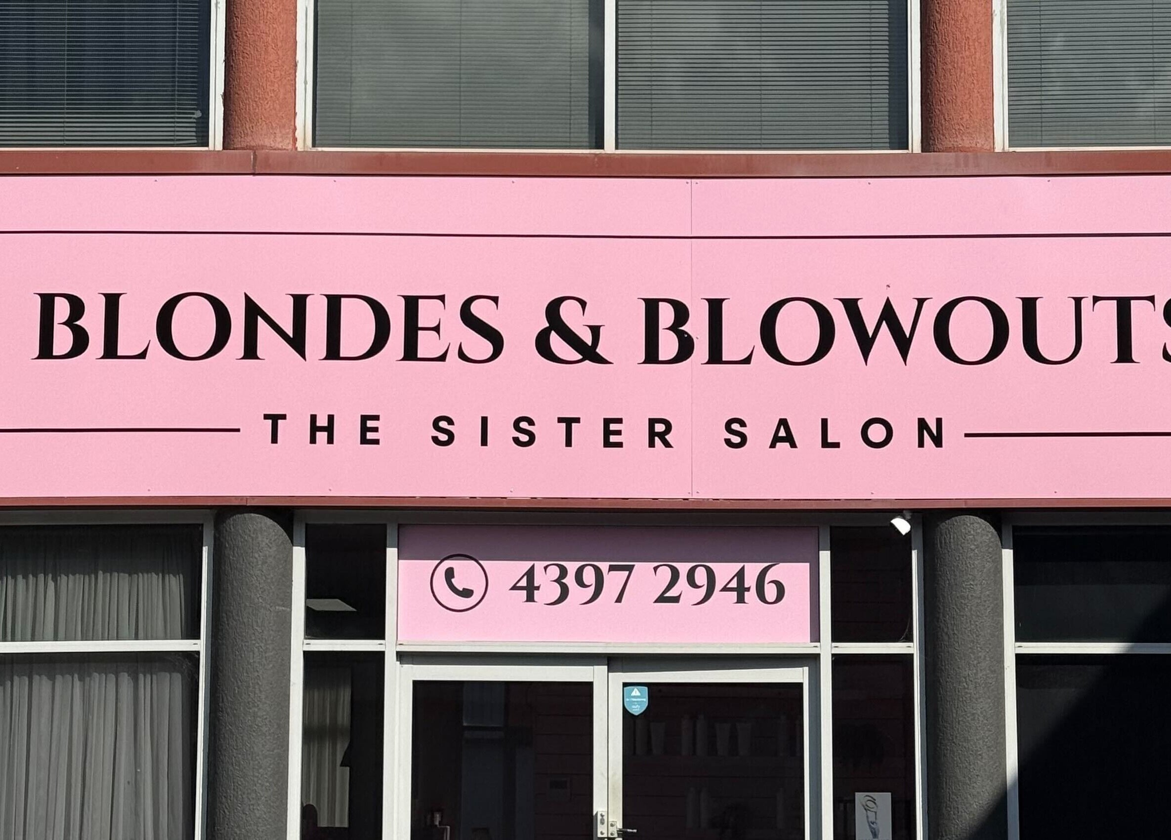 Front view of Blondes & Blowouts Tuggerah salon in Tuggerah, New South Wales, AU with a pink sign.