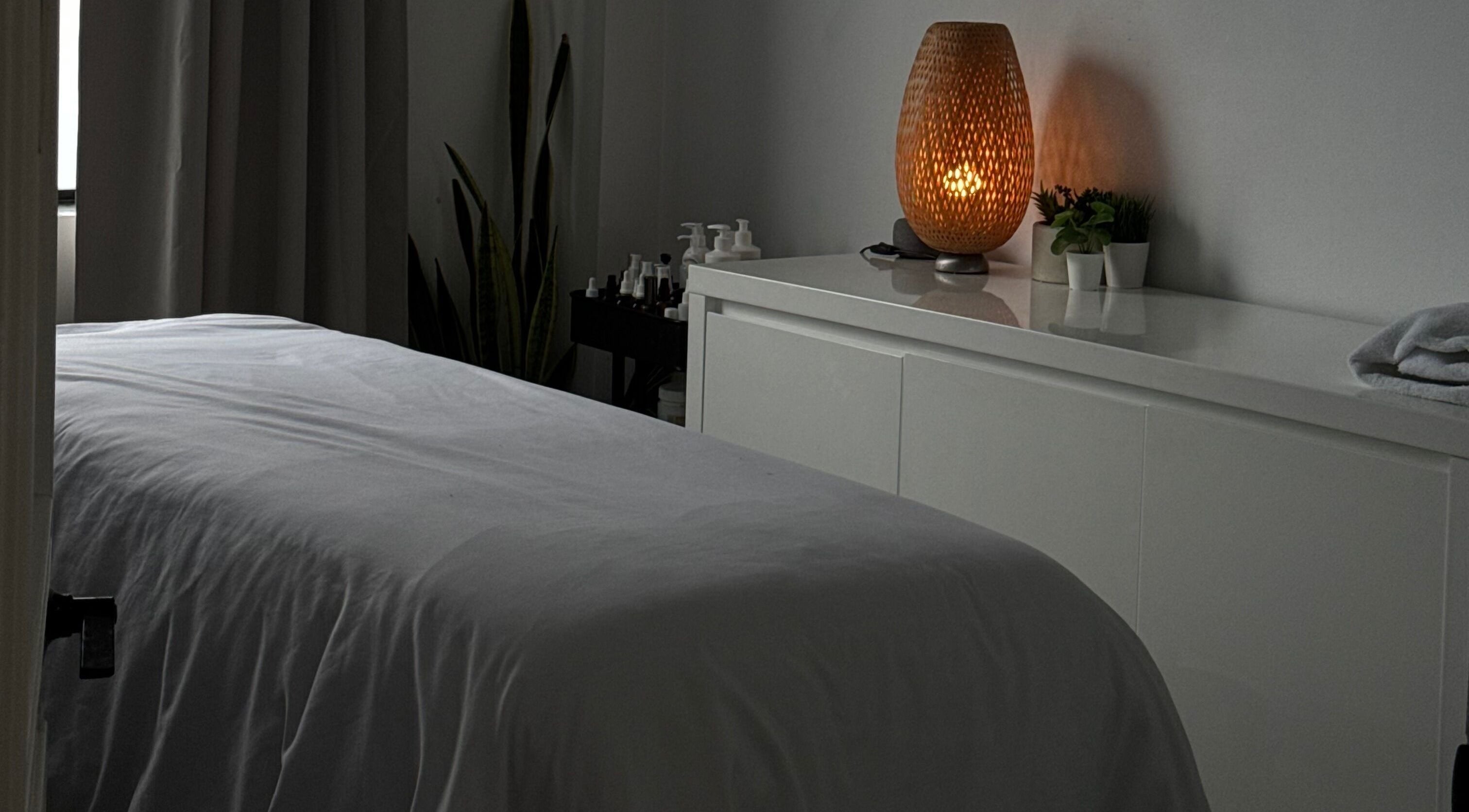 Cozy treatment room at The Brandy Alexander, Whitby, Ontario, CA, featuring a softly lit lamp.
