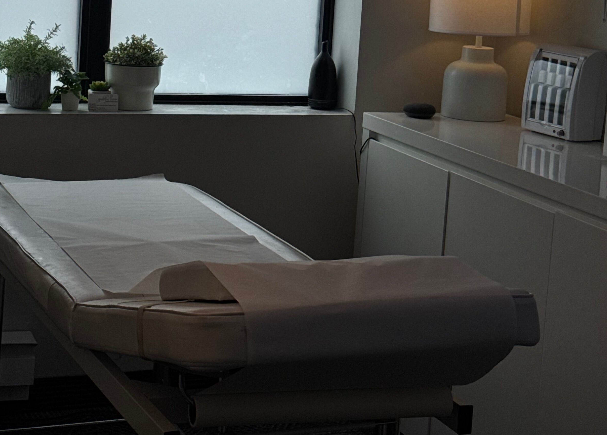 Massage table at The Brandy Alexander, Whitby, Ontario, CA, adorned with plants for a calming ambiance.